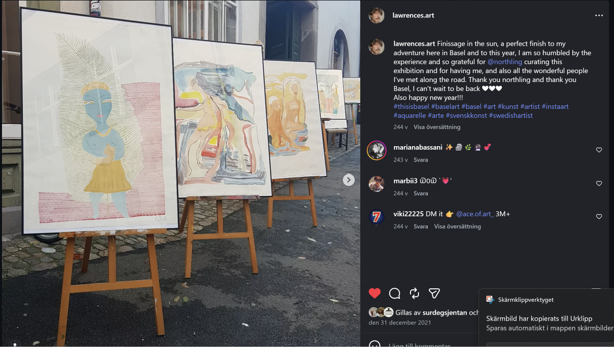 Lawrence's framed watercolours displayed on easels along a cobblestone street in Basel.